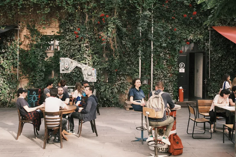 People talking around courtyard tables at Fabrika in Tbilisi