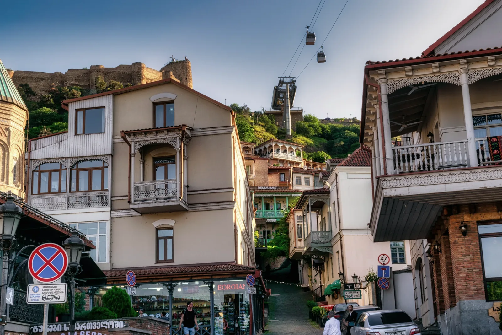 Carved balconies and an everyday street beneath Tbilisi’s old stone walls